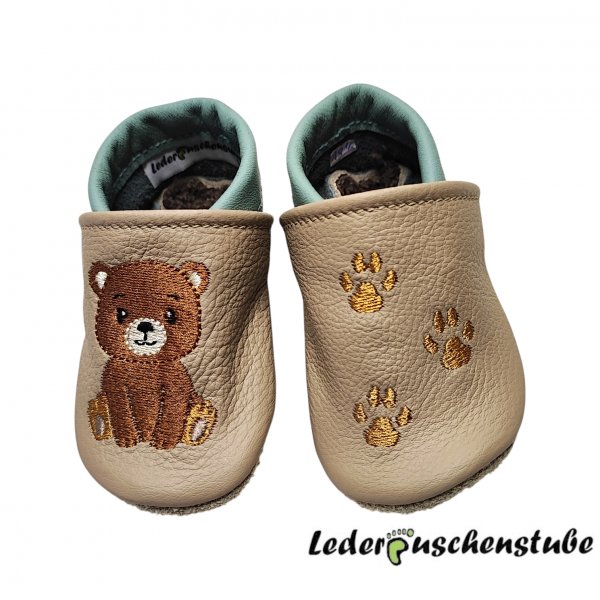 Lederpuschen beige-pistazie, mit rechts Stickerei Bär sitzt (braun-creme-schwarz-dunkelbraun) und links 3 Tatzen (braun)